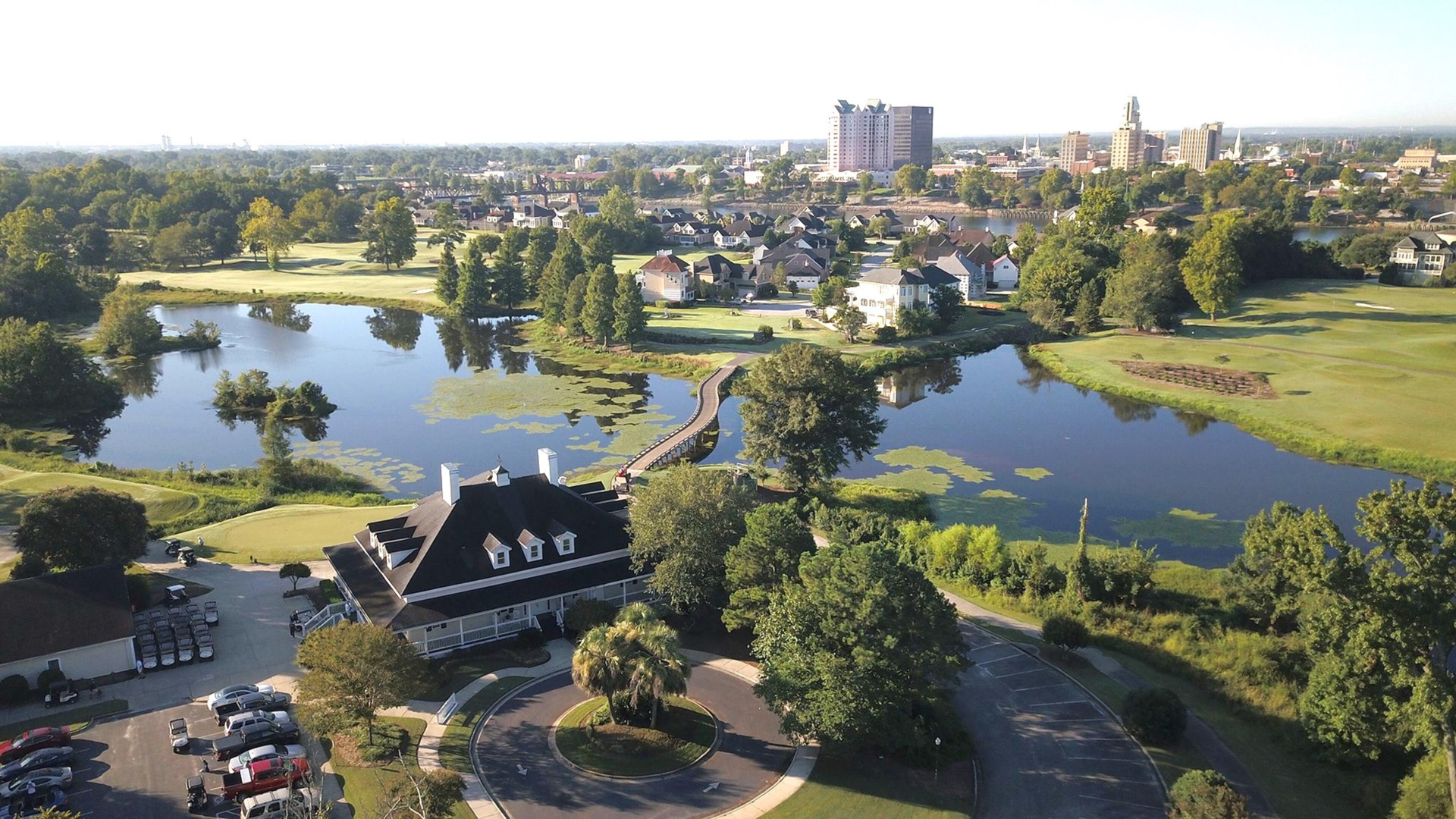 Aerial view of clubhouse, lake, and surrounding development