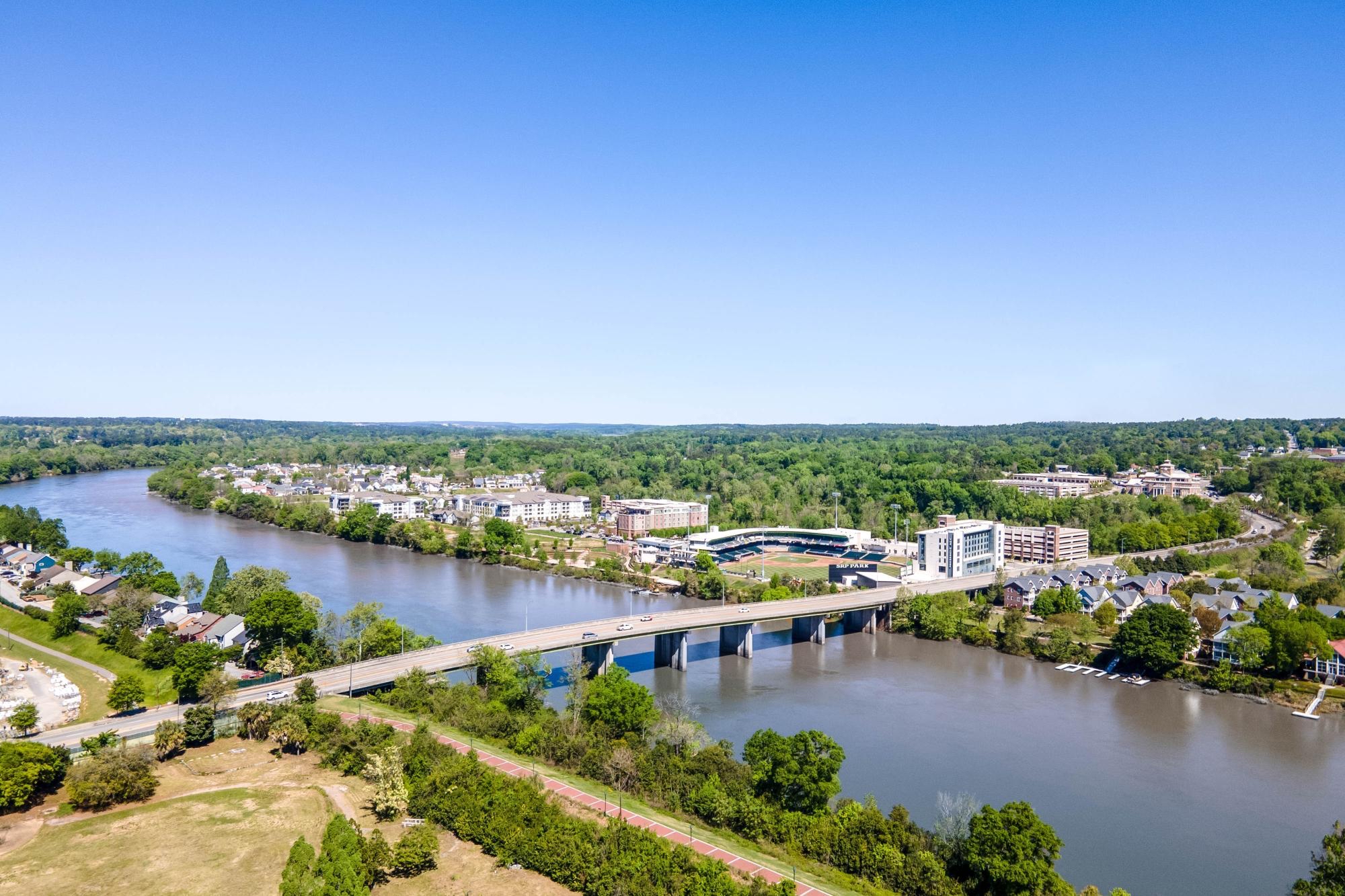 Daytime aerial of North Augusta riverfront with bridge and mixed-use district